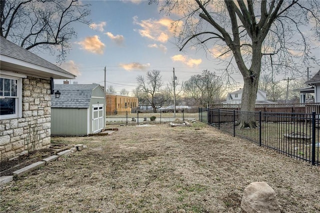 view of yard featuring a storage unit, a fenced backyard, and an outdoor structure