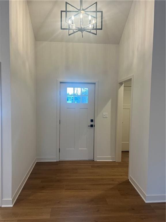 foyer featuring a chandelier, baseboards, and wood finished floors