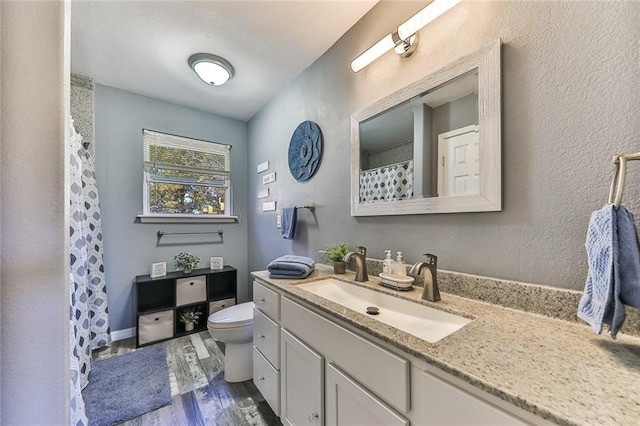 full bath featuring vanity, a shower with shower curtain, wood finished floors, and toilet