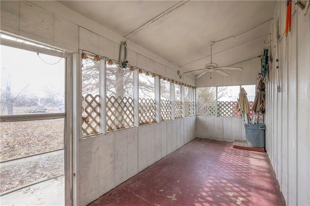 unfurnished sunroom featuring a healthy amount of sunlight, vaulted ceiling, and a ceiling fan