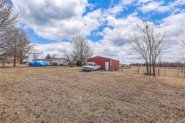 view of yard with an outbuilding, a detached garage, and fence