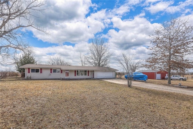 ranch-style house featuring a front lawn, driveway, and an attached garage