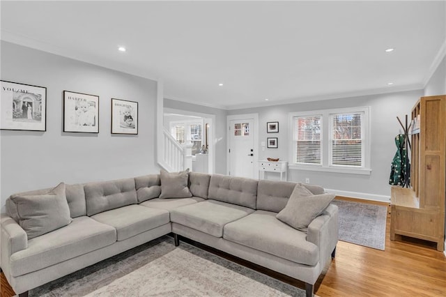 living room with light wood-type flooring, crown molding, stairway, and recessed lighting