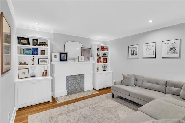 living room with crown molding, recessed lighting, a fireplace, and wood finished floors