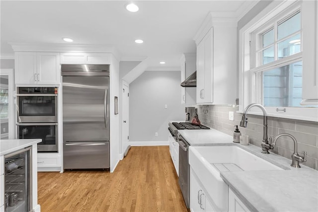 kitchen featuring crown molding, wine cooler, stainless steel appliances, and a sink