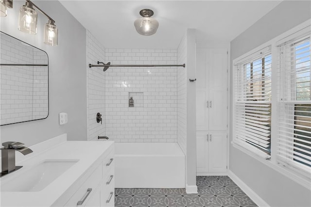 bathroom featuring bathtub / shower combination, vanity, and baseboards