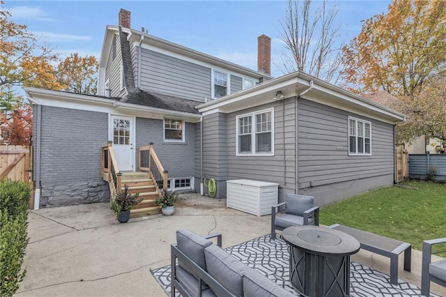 rear view of property featuring a patio, a lawn, a chimney, and fence