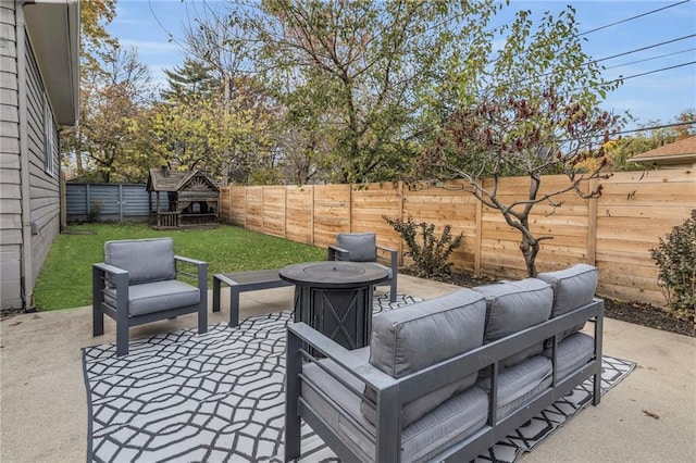 view of patio / terrace featuring a fenced backyard and an outdoor living space with a fire pit