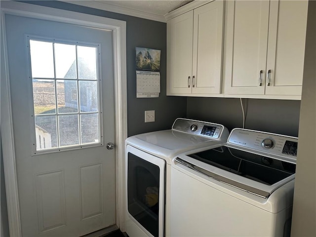 washroom with ornamental molding, washing machine and dryer, and cabinet space