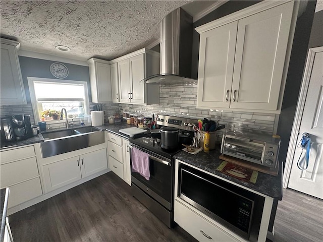 kitchen with dark countertops, wall chimney exhaust hood, electric range, and a sink