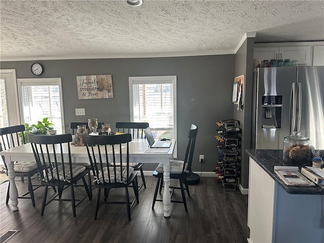 dining room with dark wood-style floors, ornamental molding, plenty of natural light, and visible vents