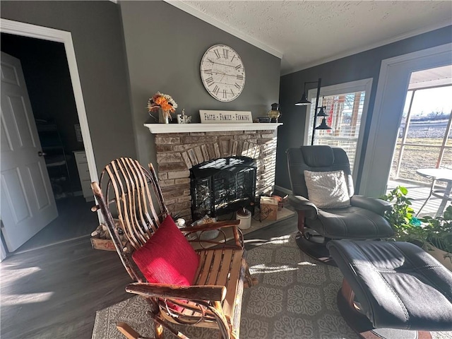 interior space with a fireplace with raised hearth, ornamental molding, wood finished floors, vaulted ceiling, and a textured ceiling