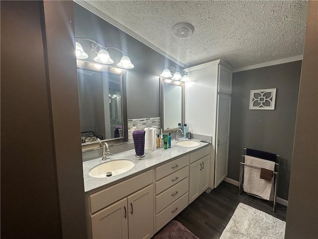 bathroom with double vanity, wood finished floors, a sink, and crown molding