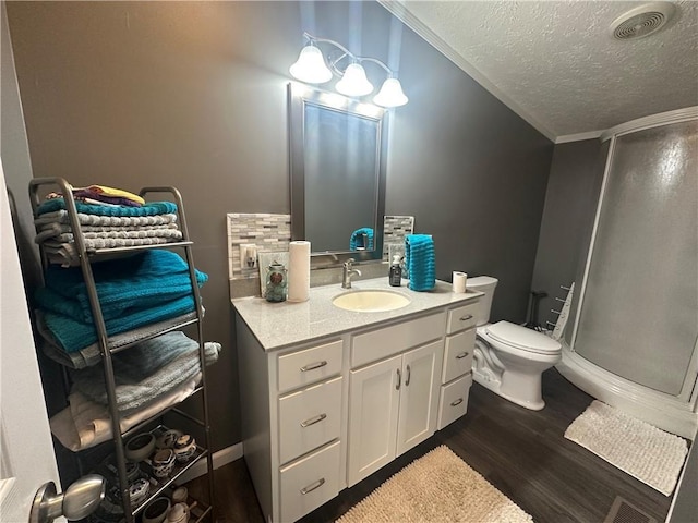 full bath with a textured ceiling, wood finished floors, a shower stall, and toilet