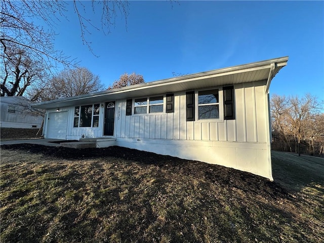 single story home with a garage and board and batten siding