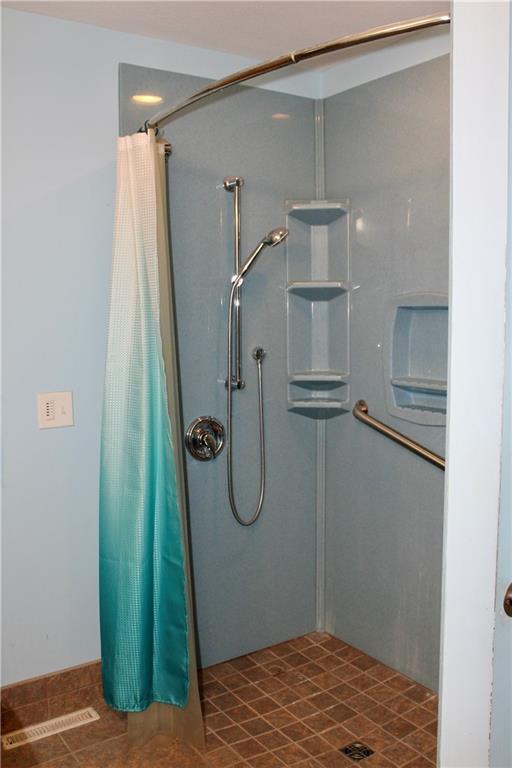 full bath featuring a shower stall and visible vents