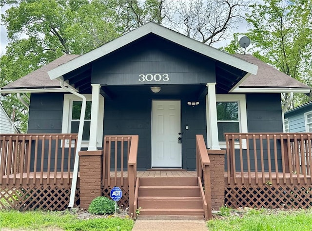 3003 E 52nd St, Kansas City, MO 64130 - bungalow featuring a shingled roof and a porch
