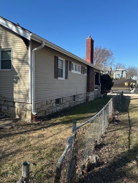 view of home's exterior with fence and a chimney