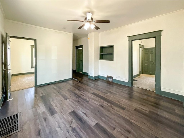 spare room featuring baseboards, visible vents, a ceiling fan, wood finished floors, and crown molding