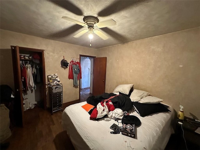 bedroom with a closet, dark wood finished floors, and ceiling fan