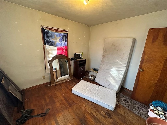 bedroom featuring hardwood / wood-style flooring and baseboards