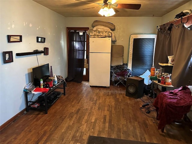 interior space with wood finished floors, a ceiling fan, and baseboards