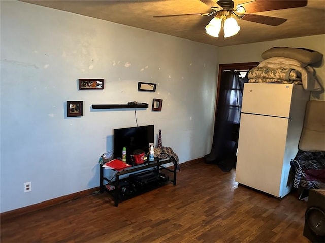 living area featuring ceiling fan, baseboards, and wood finished floors