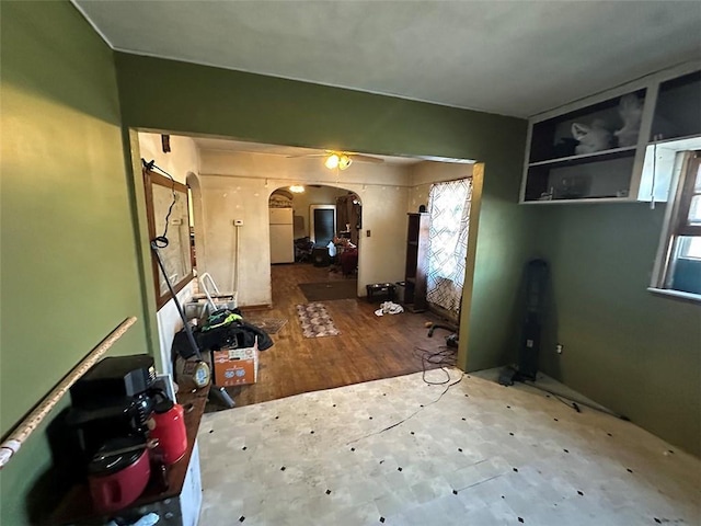 interior space featuring arched walkways and wood finished floors