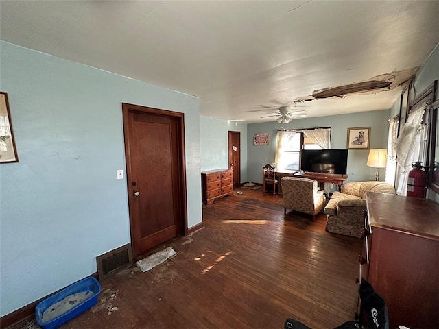 living room with dark wood-style floors, baseboards, visible vents, and ceiling fan