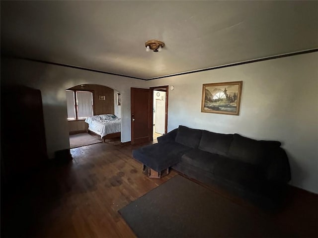 living room featuring arched walkways and wood finished floors