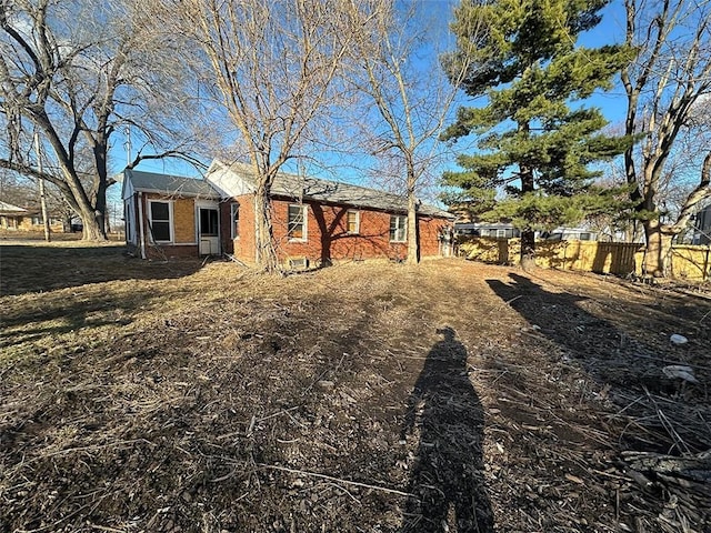 view of front of home with brick siding and fence