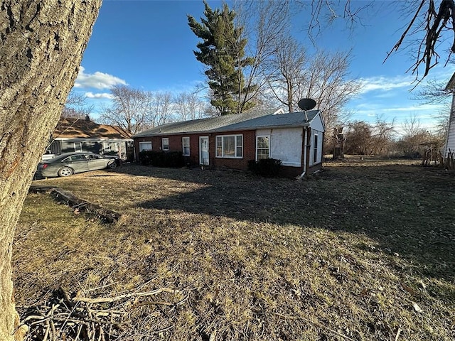 view of front facade with a front yard and brick siding