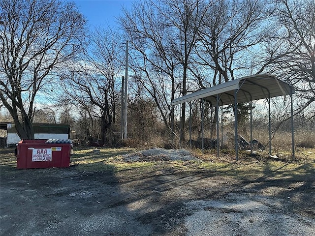 view of yard with a detached carport and driveway