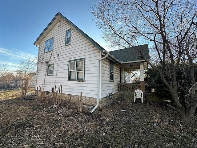 view of side of home with a shingled roof