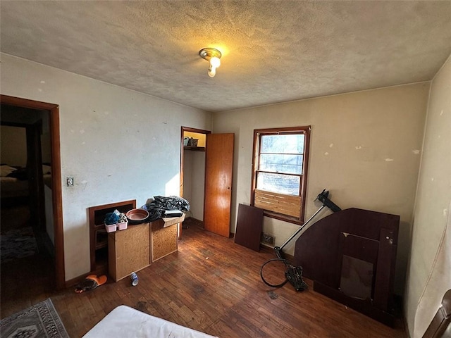 bedroom featuring wood-type flooring and a textured ceiling