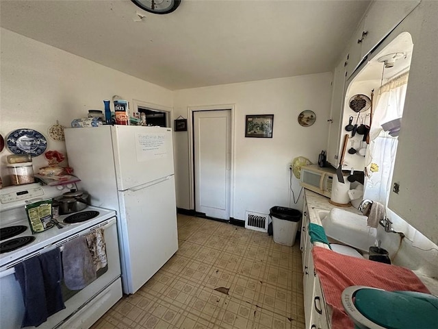 kitchen with a sink, visible vents, white appliances, and light floors