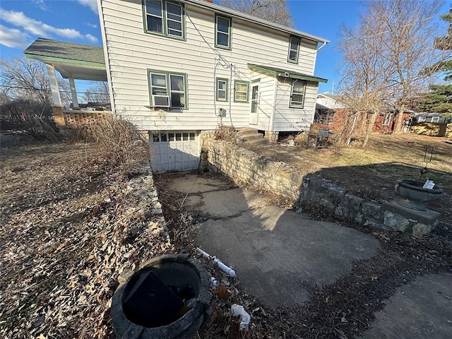 rear view of property with a garage and driveway