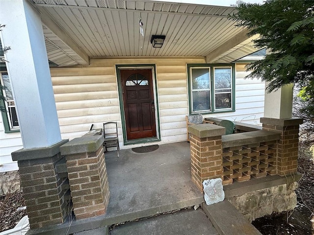 view of exterior entry featuring covered porch