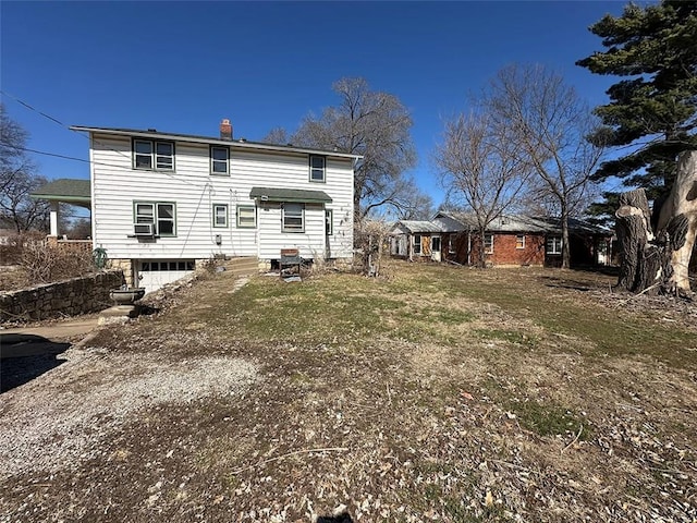 rear view of house featuring a lawn and a chimney