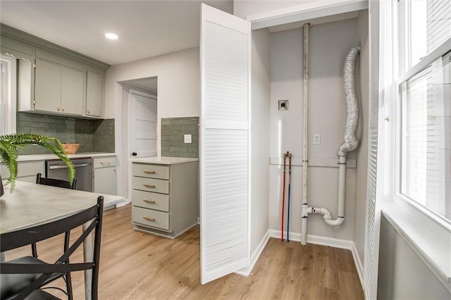 kitchen with light wood-type flooring, light countertops, backsplash, and gray cabinetry