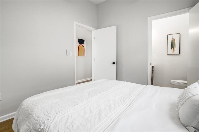 bedroom featuring baseboards and wood finished floors