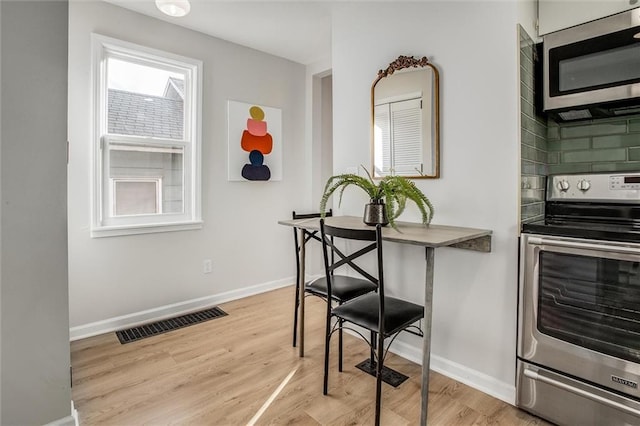 kitchen featuring light wood-style floors, visible vents, appliances with stainless steel finishes, and baseboards