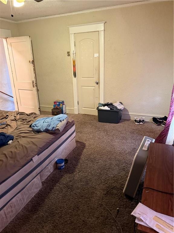 bedroom featuring crown molding, baseboards, carpet floors, a textured ceiling, and a ceiling fan