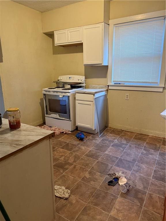 kitchen featuring light countertops, white cabinets, white electric range, and a textured ceiling