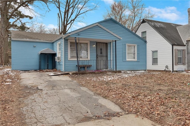 bungalow with covered porch and cooling unit