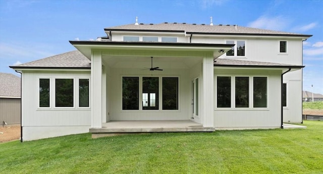 rear view of property with a lawn, a ceiling fan, and roof with shingles