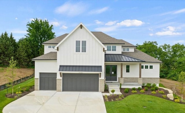 modern farmhouse style home with a shingled roof, a standing seam roof, metal roof, a garage, and driveway