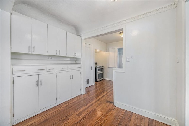 kitchen with range with two ovens, light countertops, visible vents, white cabinets, and wood finished floors