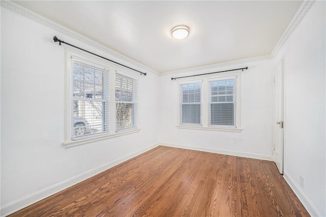 spare room featuring wood finished floors and baseboards