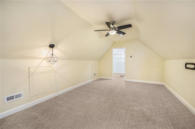 additional living space featuring baseboards, visible vents, lofted ceiling, ceiling fan, and carpet flooring